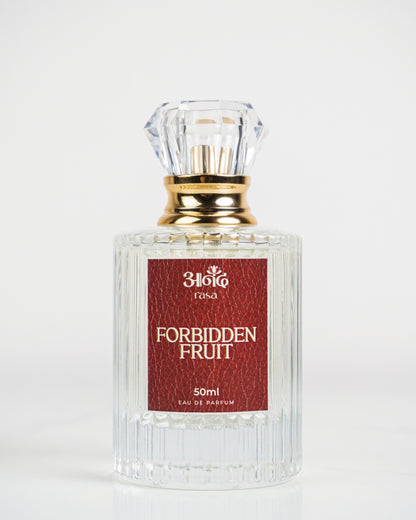 High-quality product image of Forbidden Fruit 50 ml perfume by Sakura, featuring a clear ribbed glass bottle, elegant gold cap and neck, and deep red textured label. The perfume bottle is photographed on a clean white marble background for a premium product presentation. - handcrafted attar - Anandrasa