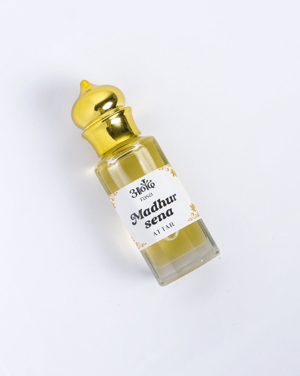 Madhur Sena Attar perfume oil bottle with golden cap on a white background