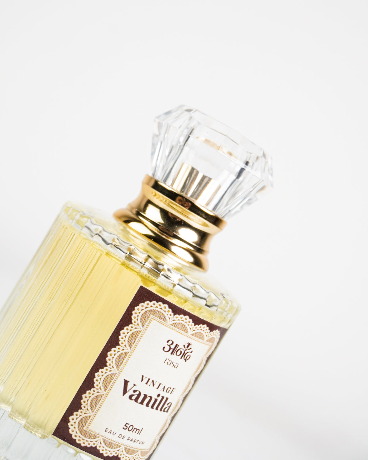 A 50ml Snake Toy Vintage Vanilla Eau de Parfum featuring a ribbed clear glass bottle filled with pale yellow fragrance, an elegant gold collar, and a faceted transparent cap, displayed on a clean white marble-style background.