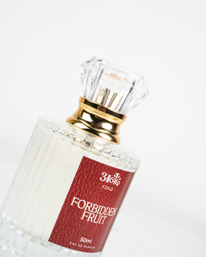 Forbidden Fruit 50 ml perfume featuring a clear ribbed glass bottle, gold neck, and deep red label on a white marble background. - handcrafted attar - Anandrasa