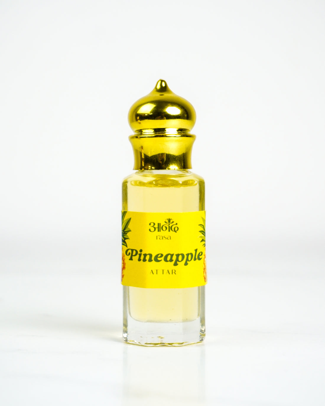 Luxury pineapple attar perfume bottle with fresh pineapple fruit and bold red background